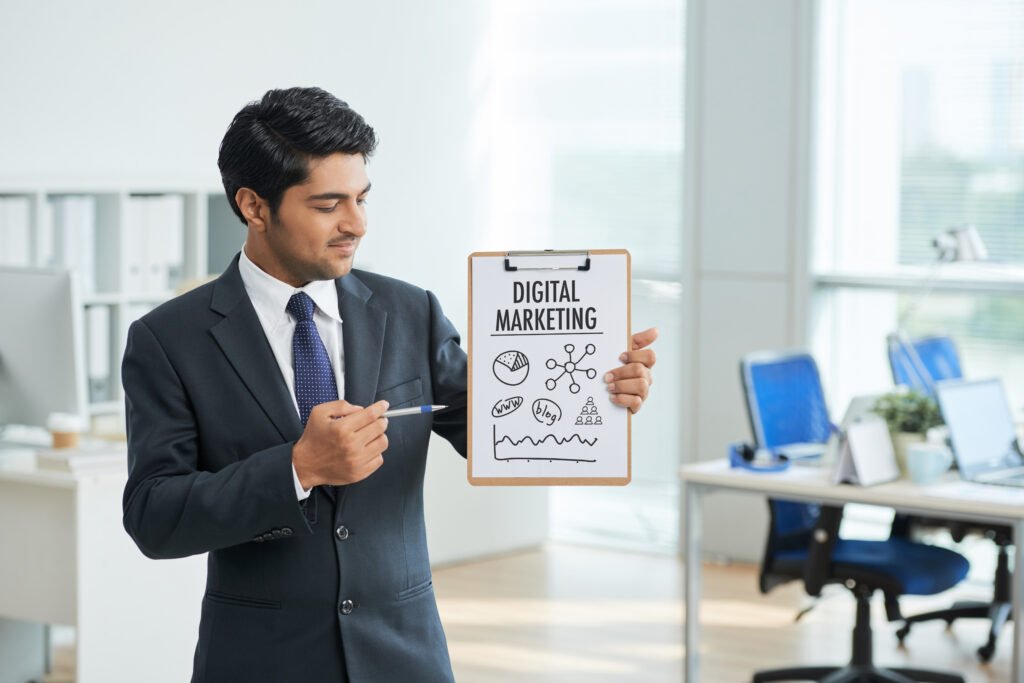 The current image has no alternative text. The file name is: man-suit-standing-office-with-clipboard-pointing-poster-with-words-scaled.jpg